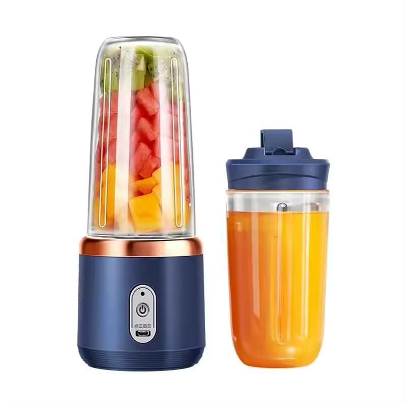 Portable blender with fruits inside and a filled juice cup on a white background